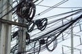 Chaotic Intertwining mess of electricity power lines on pole in Thailand