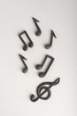 Chaotically arranged treble clef and notes on white background. Music symbol. Vertical frame