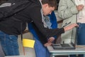 Student leaning over looking at a laptop screen