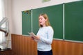 Young teacher woman in front of the class at the blackboard