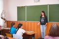 Young teacher woman in front of the class at the blackboard