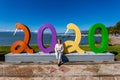 Chapala, Jalisco / Mexico, January 20. 2020. Smiling female tourist sitting among number 2020