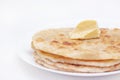 Chapatti, tortilla, fried in oil in a pan. finished dish. a piece of butter lies on fried flat cakes