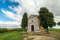 A chapel with cypresses in the center of the field. Church on a hill and green surroundings. Chapel of the Madonna di Royalty Free Stock Photo