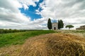 A chapel with cypresses in the center of the field. Church on a hill and green surroundings. Chapel of the Madonna di Royalty Free Stock Photo