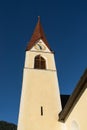 Chapel on the meadow. Bell tower, trees, shrubs and hilly green grassland. Heiliger Antoniuse church and houses in the evening lig Royalty Free Stock Photo