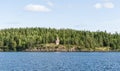 A wooden chapel on a rocky shore of the lake Royalty Free Stock Photo