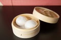 Char siew bao steamed buns with BBQ pork in a bamboo steam basket container of traditional Cantonese yum-cha Asian gourmet cuisine