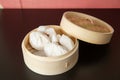 Char siew bao steamed buns with BBQ pork in a bamboo steam basket container of traditional Cantonese yum-cha Asian gourmet cuisine