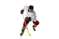 Young male hockey player with the stick on ice court and white background Royalty Free Stock Photo