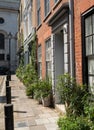 Characterful historic houses with flower pots on the pavement, on Wilkes Street in Spitalfields, East London.