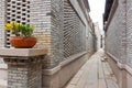 A characteristic alley of the retro style Chinese village, with brick houses and flagstone pavement, flower on pot decorated