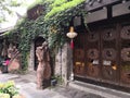 Characteristic antique small house store with statues on both sides of the door and green plants