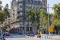 Characteristic Building of many Floors in the Center of Barcelona surrounded by Trees and a nearby Street with People, Spain