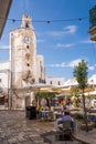 Characteristic square and tower clock with gazebo bar and people tourists in the center of Monopoli Puglia
