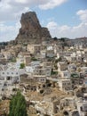 Traditional village of Capadoccia with a strange form rock in distance in Turkey.