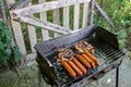 Charcoal BBQ Barbecue Grill in backyard of country side, preparing, grilling sausages and chicken on grill Royalty Free Stock Photo