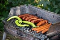 Charcoal BBQ with sausages and green papers on barbecue grill in country side house backyard Royalty Free Stock Photo