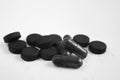 Charcoal black capsule tablets and pills in a heap on a white background Royalty Free Stock Photo