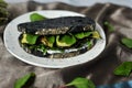 Charcoal black rye bread and roasted vegetable sandwich on a grey background