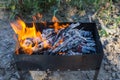 Charcoal is burned in the chargrill Cooking meat on coals. Dinner at the camp at sunset Royalty Free Stock Photo