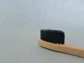 Charcoal infused bamboo toothbrush on blue texture background. Details.