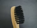 Charcoal infused bamboo toothbrush on grey black background. Close up view.