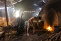 A charcoal worker at work on a pile of slow burning wood charcoal factory Royalty Free Stock Photo