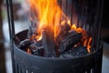 charcoals aflame in an upright chimney starter