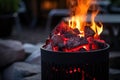 charcoals glowing red hot in a round chimney starter