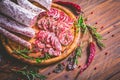 Charcuterie - Assortment of air-dried salami and sausage on wooden cutting board with spices