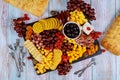 Charcuterie assortment, cheese, olives, fruits and prosciutto on wooden table