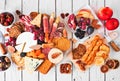 Charcuterie board overhead view table scene on a white wood background