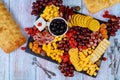 Charcuterie board assortment, cheese, olives, fruits and prosciutto on wooden table