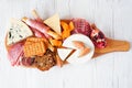 Charcuterie board of meat, cheese and appetizers over white wood Royalty Free Stock Photo
