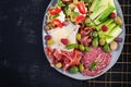 Charcuterie board. Platter: parmesan with prosciutto, salami, cucumbers and olives. Royalty Free Stock Photo