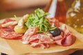 Charcuterie board with prosciutto ham, salami, herbs and olive antipasti. Gourmet platters.