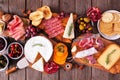 Charcuterie boards of assorted meats, cheeses and appetizers, top view table scene on rustic wood Royalty Free Stock Photo