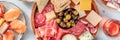 Charcuterie and cheese platter panorama with rose wine and salmon sandwiches Royalty Free Stock Photo