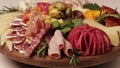 Charcuterie and cheese platter rotates smoothly around its axis. Appetizers boards with assorted cheese, salami, ham, grape and