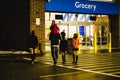 Chardon, Ohio, USA - 2-12-22: A small family gets out of a snowstorm while entering a local Walmart