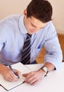 In charge of his schedule. Young businessman filling in his dayplanner. Royalty Free Stock Photo