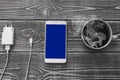 Charger, mobile phone with blue screen, coffee cup