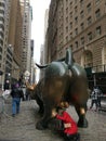 Charging Bull bronze sculpture where people stand in a line to take pictures touching the bulls testicles