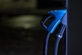 Charging cable handle docked at a fast electric vehicle charger..