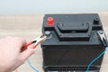 Charging car battery with electric current. Close up of hand Charging car battery with electricity trough jumper cables Royalty Free Stock Photo