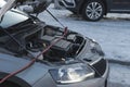 Charging a car battery in winter. Help on the road. Close-up. Connecting high voltage wires to the car battery. Resuscitation of Royalty Free Stock Photo