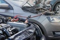 Charging a car battery in winter. Help on the road. Close-up. Connecting high voltage wires to the car battery. Resuscitation of Royalty Free Stock Photo