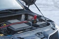 Charging a car battery in winter. Help on the road. Close-up. Connecting high voltage wires to the car battery. Resuscitation of Royalty Free Stock Photo