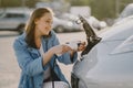 Woman charging electro car at the electric gas station